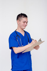 Portrait of a young and bubbly medical student, intern, nurse writing something at a checklist...