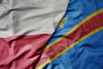 big waving national colorful flag of poland and national flag of democratic republic of the congo .