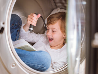 Amazed boy reading book in washing machine