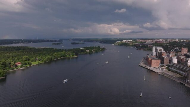 Aerial view of boats passing on water surface around historic Kvarnen Tre kronor on waterfront. Stockholm, Sweden