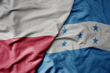 big waving national colorful flag of poland and national flag of honduras .