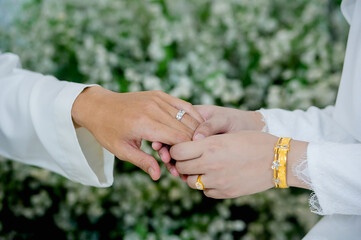 muslim groom in white suite hold hangs finger of muslim bride.concept for wedding card background, poster,Invitation card