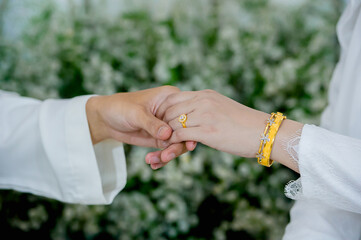 muslim groom in white suite hold hangs finger of muslim bride.concept for wedding card background, poster,Invitation card