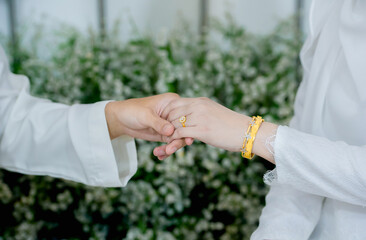 muslim groom in white suite hold hangs finger of muslim bride.concept for wedding card background, poster,Invitation card