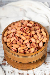Pistachios in wooden bowl. Pistachios on white wood background