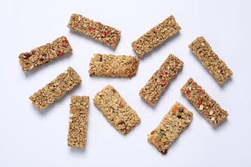 Tasty granola bars on white background, flat lay