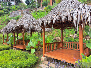 Typical tropical modern gazebo with wooden floors, timber structure, straws ceiling and palm thatch roof. This gazebo is common in tropical countries and particularly in southeast Asia Indonesia, Thai