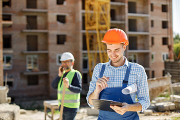 Two men engineers at a construction site doing their job