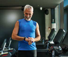 gym sport fitness exercising training mature man running watch smart time smartwatch wristwatch device app checking pulse monitor performance cardio treadmill