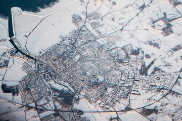 Aerial view over town and snowy fields from airplane