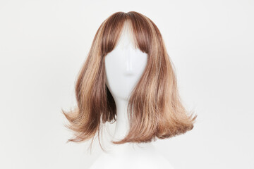 Natural looking dark brunet wig on white mannequin head. Middle length brown hair on the plastic...