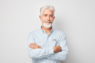 Portrait of confident mature businessman with serious face and gray hair isolated on studio background. Good looking 60 year old man, boss in business casual.