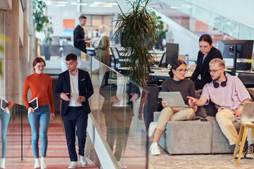 In a modern startup office, a diverse group of young professionals collaboratively tackles various...