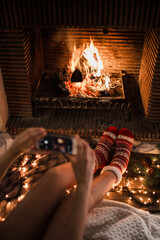 Crop female taking picture of fireplace