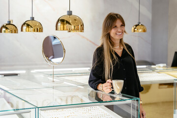 Positive friendly mature middle age beautiful female business owner in a jewelry shop, portrait.