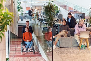 A company director assists his business colleague in a wheelchair, helping her navigate to their...