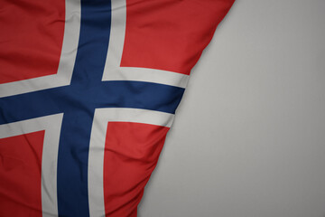big waving national colorful flag of norway on the gray background.