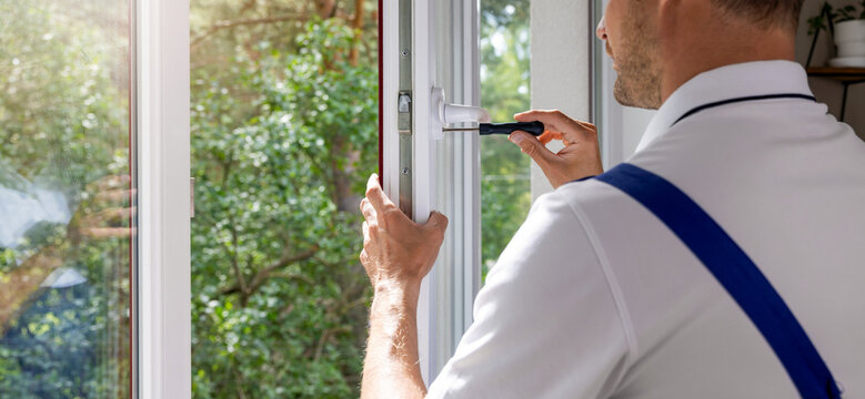 worker installing plastic PVC window handle. maintenance and repair. banner with copy space