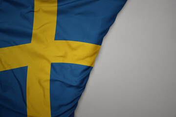 big waving national colorful flag of sweden on the gray background.