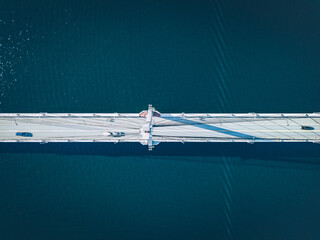Aerial view of suspension bridge road over blue lake or sea in Finland