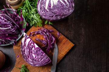 Chopped red cabbage close-up on a cutting wooden board in the kitchen. Copy space