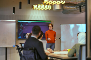 A pregnant business woman with orange hair confidently presents her business plan to colleagues in a modern glass office, embodying entrepreneurship and innovation