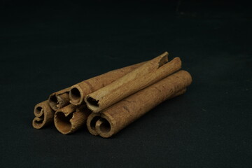 stacked Cinnamon sticks on black background