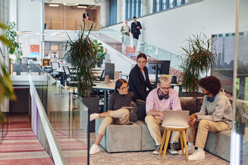 In a modern startup office, a diverse group of young professionals collaboratively tackles various...