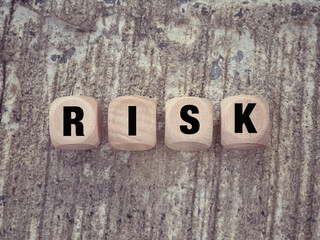 Business and financial concept. Word RISK written on wooden blocks. With blurred styled background.