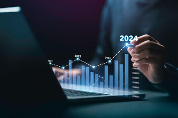 Businessman analyzes the graph of trend market growth in 2024 and plans business growth and profit...