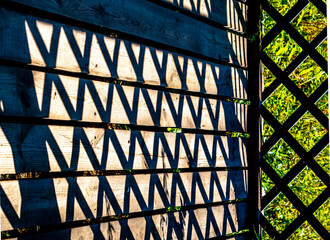 Shadows from the lattice on the wooden wall.