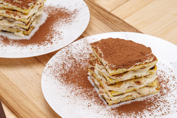 A piece of homemade layer cake, banana with cocoa, on a white plate. 