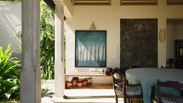 Abstract painting with blue trees in leaving room of retro villa on tropical island. Vintage picture art object on exotic resort with evergreen garden. Designer interior with furniture decorations.