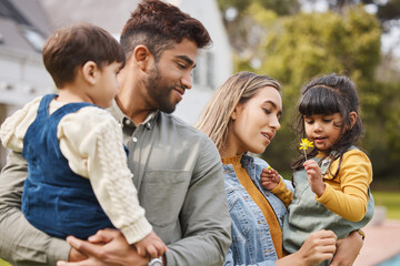 Mother, father and children outdoor with a flower in spring with love, care and security. A man, woman or parents and kids together in a family backyard to relax while bonding on holiday or vacation