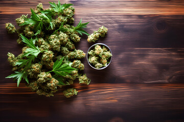 Marijuana buds close up. Medicinal cannabis flowering on wood tabletop background. Hemp recreation, medical use, legalization.