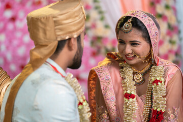 Indian happy Newly married young couples on stage talking together during reception ceremony -...