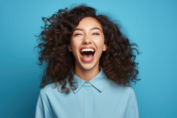 excited screaming young woman standing isolated on blue background