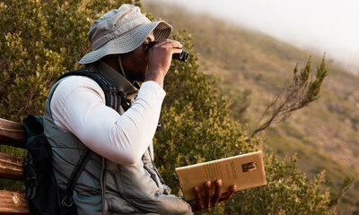 Book, binocular or man bird watching in nature on trekking adventure journey for wellness or peace....