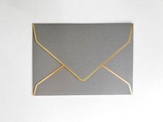 Silver envelope with a white liner for congratulations on a white background. Wedding invitation, for business, postcard. Flat lay, top view, copy space.