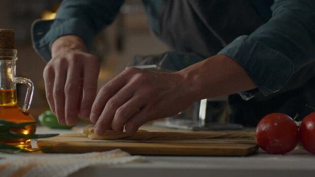 Pasta, the cook concentratedly puts spaghetti pasta into nests in a pile of specialized bakery. Smooth camera movement Pasta maker serving customers masters new pasta cooking techniques, pasta roller