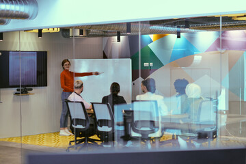 A pregnant business woman with orange hair confidently presents her business plan to colleagues in a modern glass office, embodying entrepreneurship and innovation