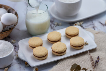 process of assembling tapas and cornstarch alfajores with dulce de leche and coconut with milk eggs sugar everything with white bajilla