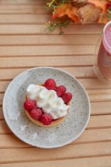 Aesthetic healthy autumn lunch - pink strawberry smoothie and french tart on the wooden table