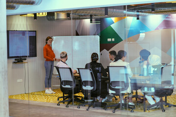 A pregnant business woman with orange hair confidently presents her business plan to colleagues in a modern glass office, embodying entrepreneurship and innovation