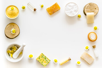 Frame of cosmetic beauty products with chamomile flowers and herbs