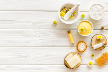 White and yellow chamomile flowers with herbal cosmetic beauty products