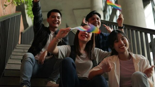 Asian students have gender diversity at university. Sit on the stairs holding the rainbow flag. education concept. LGBT