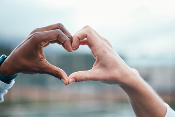 Outdoor, closeup and people with heart sign, hands and support with kindness, emoji and commitment. Outside, couple or interracial with symbol for love, trust and partnership with care, icon and like