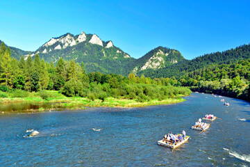 Summer landscape of Pieniny mountains. Traditional rafting on the Dunajec River on wooden boats. The rafting is very popular tourist attraction in Pieniny National Park