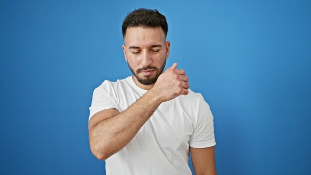 Young arab man sneezing over isolated blue background